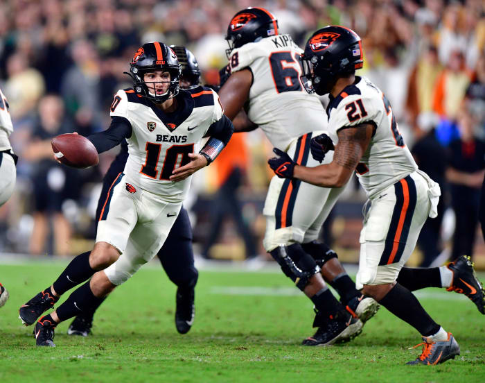 Oregon State quarterback Chance Nolan (10) hands the ball off to running back Trey Lowe (21).
